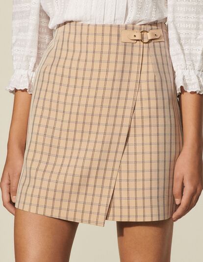 Una minifalda cruzada, de cuadros y con hebilla que te recordará a esas que llevabas cuando eras una adolescente. Ahora podrás llevarla a la oficina combinada con una camisa o en tus fines de semana con zapatillas. Es de Sandro y cuesta 195€.