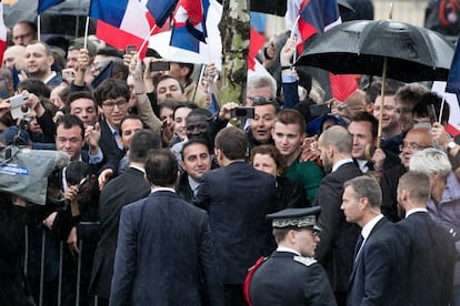 El nuevo presidente francés, Emmanuel Macron, saluda a los ciudadanos que se han acercado a los Campos Elíseos con motivo de la ceremonia de investidura.