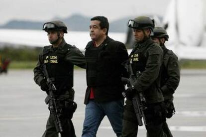 El presunto guerrillero de las FARC, Joaquín Pérez Becerra, es custodiado por la policía a su llegada a Bogotá el pasado lunes