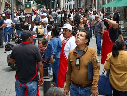 Capitalinos en una calle del Centro Histórico al escuchar la alerta sísmica, este lunes.