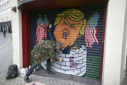 Jack Dones pinta un graffiti de Donald Trump en un comercio de la ciudad brit&aacute;nica de Bristol.