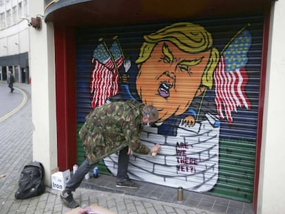 Jack Dones pinta un graffiti de Donald Trump en un comercio de la ciudad brit&aacute;nica de Bristol.