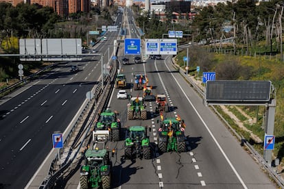 Una columna de tractores entra a Madrid por la calle O'Donnell, en la carretera M-23, escoltados por vehículos de la Policía Nacional, este lunes. 