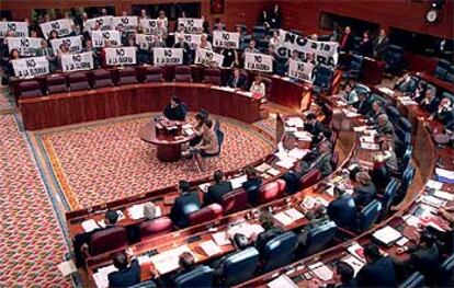 Los diputados del PSOE y de IU despliegan pancartas contra la guerra de Irak en la Asamblea.