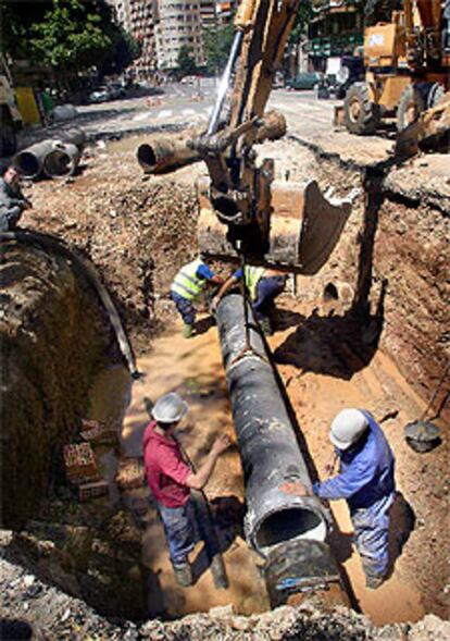 Operarios de la compañía de aguas reparan la avería.