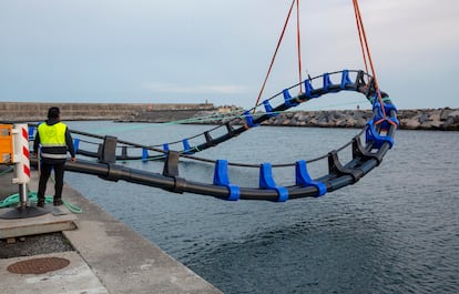 Momento en el que el aro flotante para la cría de atunes se lanza al agua en el puerto de Orio (Gipuzkoa).