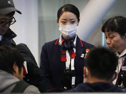 Una azafata de Japan Airlines con mascarilla en el aeropuerto de Los Ángeles, EE UU.