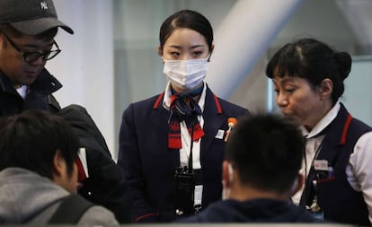 Una azafata de Japan Airlines con mascarilla en el aeropuerto de Los Ángeles, EE UU.