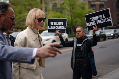 E. Jean Carroll llega a al tribunal federal de Nueva York junto a un manifestante con pancartas en contra del expresidente Donald Trump.