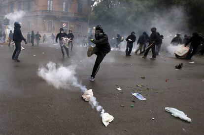 Un manifestante patea una lata de gas lacrimógeno durante los enfrentamientos con la policía italiana durante una protesta en contra de la feria Exposición Universal 2015 en Milán.