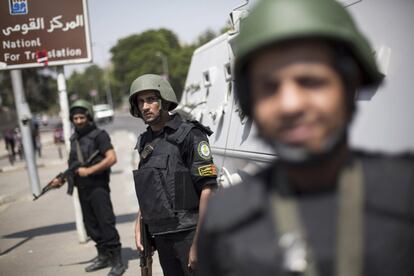 Policías egipcios protegen el cruce entra la plaza de Tahrir y la Universidad de El Cairo donde los partidarios de la Hermanos Musulmanes se han reunido, para defender al presidente egipcio.