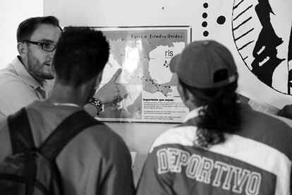 Un voluntario muestra a dos inmigrantes un mapa con las principales rutas a través de México para llegar a Estados Unidos.