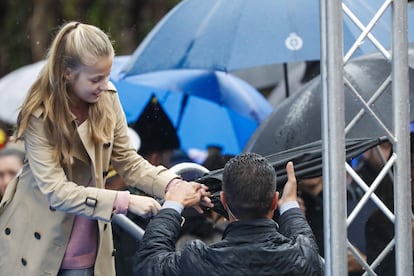 La princesa Leonor le da su paraguas a uno de los miembros del equipo de seguridad que viaja con la familia real.