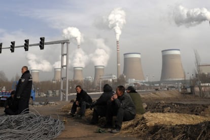 Trabajadores chinos ante una planta industrial en Dadong.