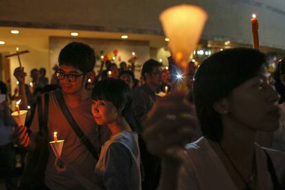 Decenas de personas sostienen velas durante una campaña contra la violencia en el centro de Bangkok (Tailandia).