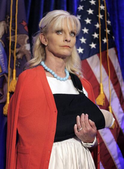 Cindy McCain muestra su brazo derecho en un cabestrillo en un acto de su esposo en el estado de Michigan