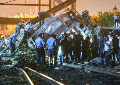 Miembros de los servicios de emergencia trabajan en el tren que descarriló esta noche en Filadelfia y dejó al menos cinco muertos y 50 heridos.