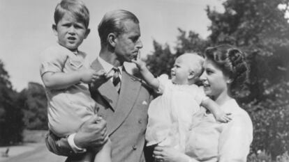 Felipe de Edimburgo, con Carlos, su hijo mayor, mientras su mujer, aún princesa, tiene en brazos a Ana, en agosto de 1951 en su residencia de Clarence House.