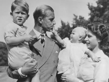 Felipe de Edimburgo, con Carlos, su hijo mayor, mientras su mujer, aún princesa, tiene en brazos a Ana, en agosto de 1951 en su residencia de Clarence House.