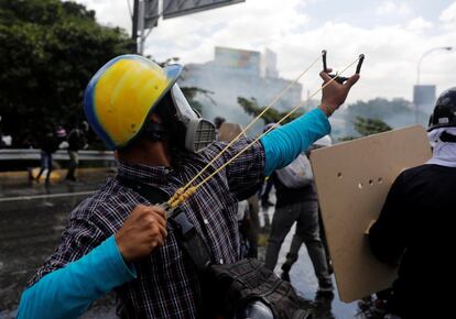 Un joven utiliza un tirachinas para enfrentarse a la policía.