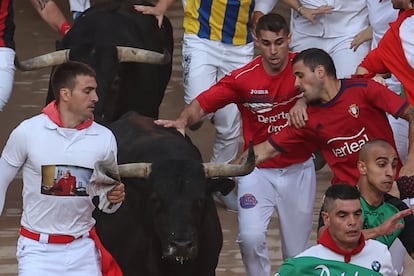 Unos mozos corren junto a uno de los toros de Victoriano del Río, este jueves en Pamplona.