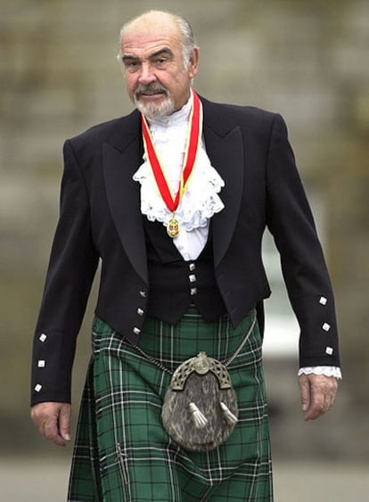 Connery fue nombrado caballero por la reina Isabel II en el año 2000. En la foto acude vestido con el traje típico de las Highlands al palacio de Holyrood, en Edimburgo, donde se celebró el nombramiento. Abajo, una imagen del actor en el papel de agente 007.