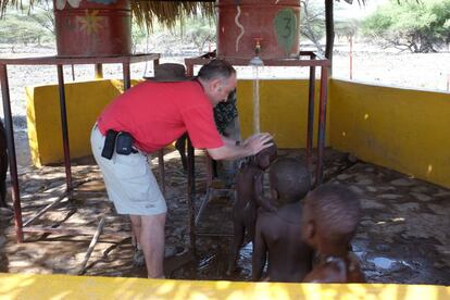 Jaime Castro ba&ntilde;a a unos ni&ntilde;os en Turkana (Kenia), donde Merck ha financiado un pozo.