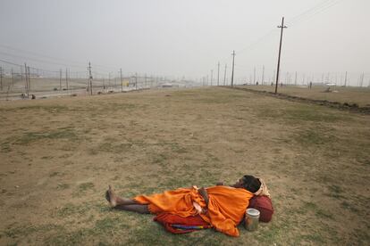 Un sadhu descansa en el suelo, en Sangam (India).