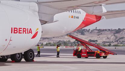 Personal de tierra de Iberia atiende a un avión de la aerolínea.