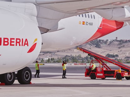 Personal de tierra de Iberia atiende a un avión de la aerolínea.