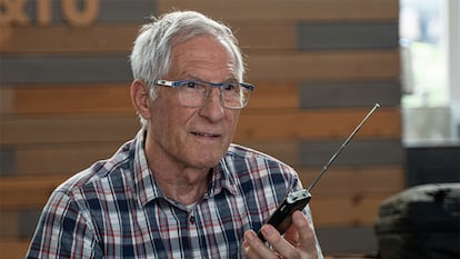 Una persona mayor con una radio en la mano.