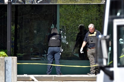 A Louisville Metro Police crime scene technician photographs bullet holes in the glass of the Old National Bank building in Louisville, Kentucky, on April 10, 2023.