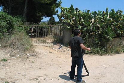 Un cámara de televisión toma imágenes en la puerta de la huerta de Sitges donde ayer se produjo el suceso.