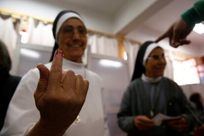 Duas freiras mostram seus dedos manchados de tinta após votar no Cairo.