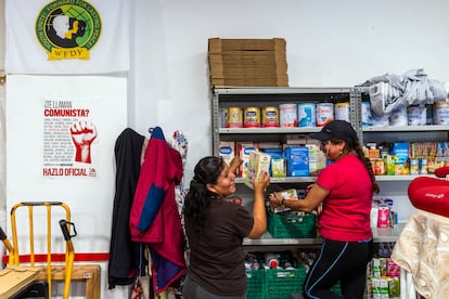 Erika Guillén (a la izquierda) y otra miembro de la Asociación Vecinal Somos Red Entrepozo VK organizan el estante de comida para bebé.