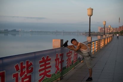 Um habitante da cidade chinesa de Dandong realiza exercícios no passeio do rio Yalu.