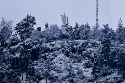 Una estatua de la Virgen María en la cumbre de la columna de San Cristóbal, en Santiago de Chile, el pasado 15 de julio de 2017. Temperaturas récord y una nevada poco habitual cayeron ese día en la capital. Las temperaturas normales no se recuperarían hasta días después.