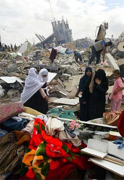 Palestinos rebuscan en las ruinas de sus casas demolidas por Israel.
