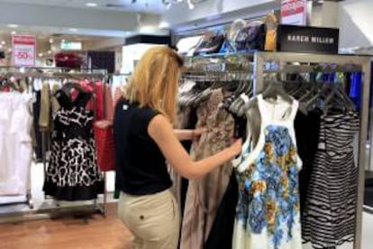 Una mujer compara vestidos en unos grandes almacenes de Madrid. EFE/Archivo