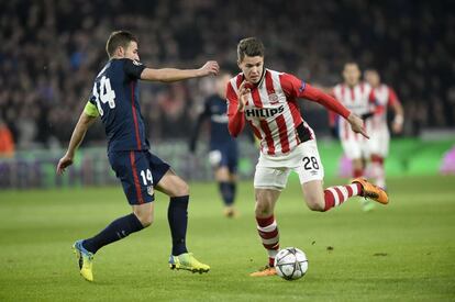 El centrocampista del Atlético de Madrid Gabi y el jugador del PSV Marco van Ginkel luchan por el balón durante el partido de ida de los octavos de final de la Champions League.