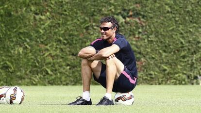 Luis Enrique mira el entrenamiento sobre un balón.