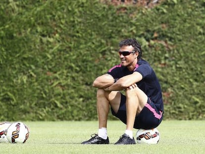 Luis Enrique mira el entrenamiento sobre un balón.