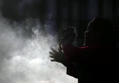 Una mujer quema incienso mientras reza en la estupa de Boudhanath, en Kathmandu (Nepal). Una estupa es un tipo de arquitectura budista y yaina hecha para contener reliquias, que deriva probablemente de los antiguos túmulos funerarios. Este edificio se encuentra extendido por todo el sudeste asiático.