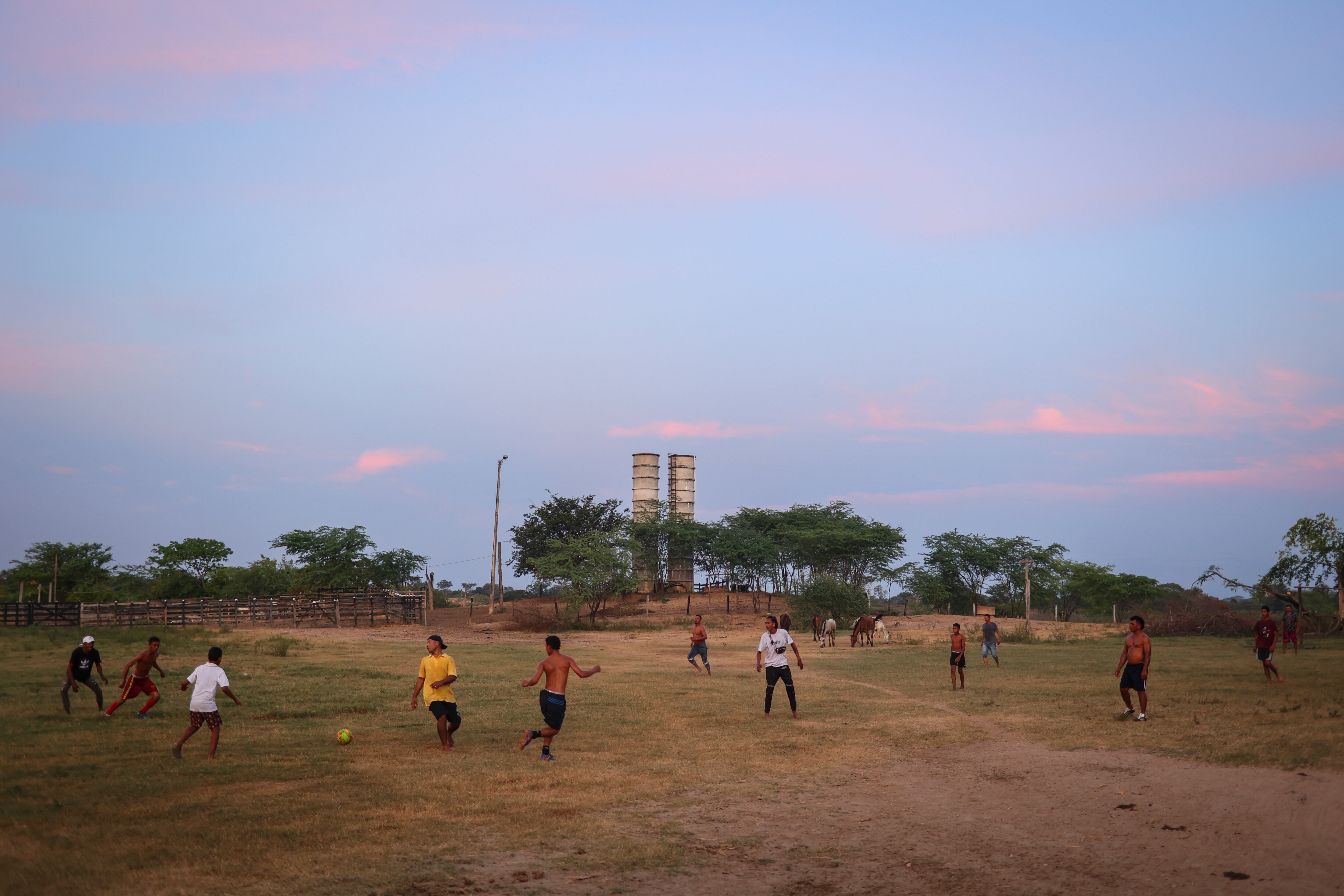 Jóvenes fuegan fútbol al caer la tarde en una cancha improvisada en la finca La América, en el departamento de Cesar.