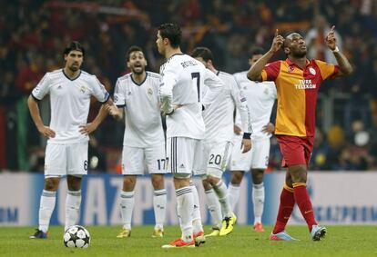 Drogba celebra un gol mientras los jugadores del Madrid discuten.