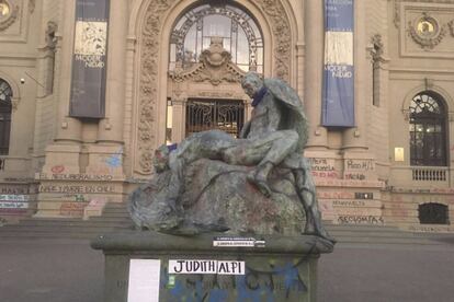 Una escultura frente al Museo Nacional de Bellas Artes con un cartel que hace referencia a la pintora y activista Judith Alpi.