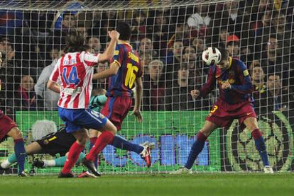 Piqué saca, con la cabeza y al borde de la línea de gol, un balón de Filipe Luis.