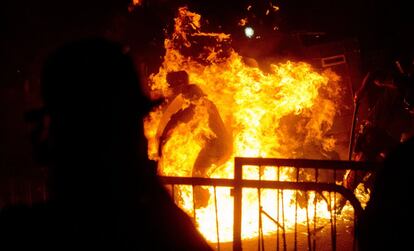 Un policía brasileño envuelto en llamas durante los enfrentamientos con los manifestantes en Río de Janeiro (Brasil), 22 de julio de 2013. Los enfrentamientos han tenido lugar cerca del palacio Guanabara, sede del Gobierno local, poco después de la salida del recinto del Papa Francisco, que ha dado en él su primer discurso tras su llegada al país sudamericano.