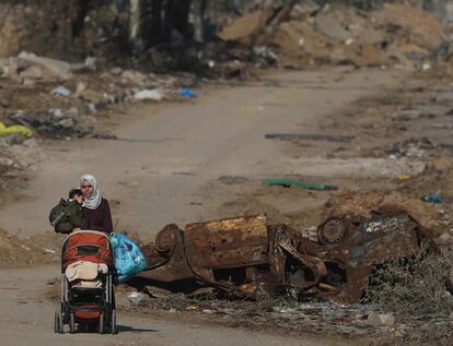 Una mujer palestina transporta a un niño mientras huye del norte de Gaza para dirigirse a las zonas del sur, a través de la carretera Salah Al Din, este miércoles.
