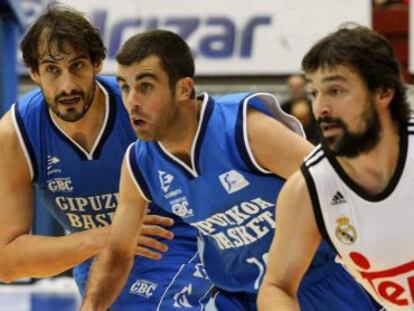 El base del Real Madrid Sergio Llull avanza con el balón ante los jugadores del Gipuzkoa Basket Jared Jordán, en el centro, y David Doblas.